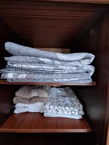 a stack of towels on a wooden shelf at Rovshan's house in Sheki +27 photos
