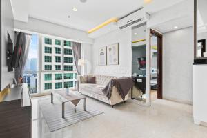 a living room with a couch and a large window at Charme by Kozystay - Setiabudi in Jakarta