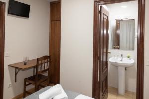 a bathroom with a bed and a sink and a mirror at Pensión A Codeseira Melide in Melide +70 photos
