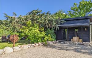 a black house with a gravel yard in front of it at Gorgeous Home In Hasslö With Kitchen in Hasslö +9 photos