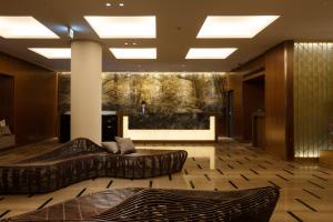 a lobby with two couches and a large painting at Hotel Forza Kanazawa in Kanazawa