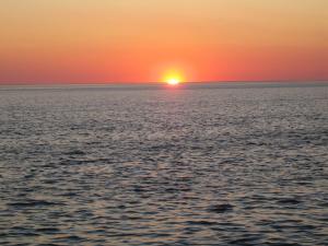 einen Sonnenuntergang über dem Meer mit Sonnenuntergang in der Unterkunft Haus Halligblick, Ferienwohnungen am Wattenmeer, Whg Gröde in Dagebüll + 10 Fotos