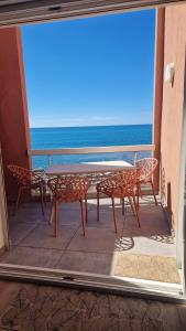 Ein Tisch und Stühle auf einem Balkon mit Meerblick in der Unterkunft CAP CORNICHE - Agréable Studio bord mer in Sète