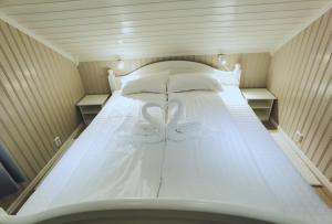 una cama blanca con una decoración de corazón. en BanPim Beachside Lofoten, en Ramberg