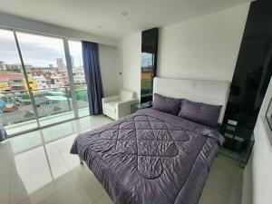 Un dormitorio con una cama y una ventana grande. en City Center Residence CCR, en Pattaya central 21 fotos más