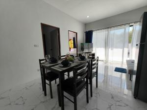 Nathon BayにあるWaan Samui Pool Villaのダイニングルーム(テーブル、椅子、テレビ付)