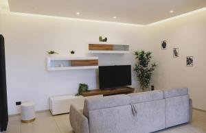 Una sala de estar con un sofá y un televisor de pantalla plana. en Casa Nuvola, en Vietri