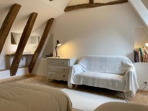a bedroom with a bed and a chair and a dresser at L'Épicerie de Bezenac in Bézenac