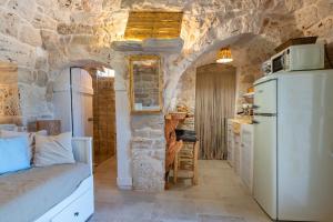a kitchen with a stone wall and a refrigerator at Il Trullo di Mariangela in Ceglie Messapica