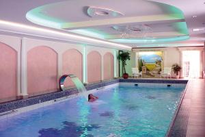a person swimming in a swimming pool in a hotel at Vis á Vis Parkhotel in Willingen