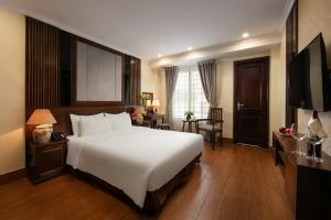 a hotel room with a large bed and a television at The West Hotel & Spa in Hanoi