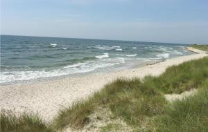 a sandy beach with the ocean in the background at Holiday Home I Klitterne Nexø I in Spidsegård