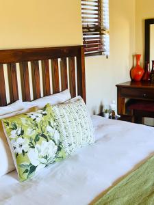 a bed with a pillow sitting on top of it at 213 Zebula Golf Estate & Spa - 4 Bedroom Home in Mabula +10 photos