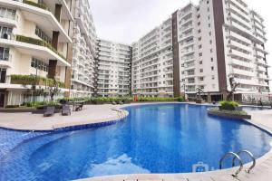 a large swimming pool in front of some buildings at Best Location Studio Room at Gateway Pasteur Apartment By Travelio in Bandung