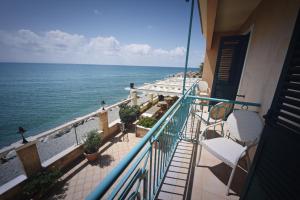 einen Balkon mit Stühlen und Meerblick in der Unterkunft Hotel Ristorante La Lampara in Gizzeria