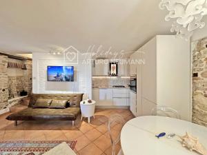 a living room with a couch and a table at 124 - Deliziosa casa cielo-terra a Numana in centro storico, con splendida vista sul mare - SPIAGGIA WHITE BEACH CLUB OMAGGIO dal lun al ven FINO AL 02-08 in Numana +12 photos