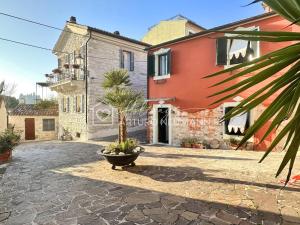 an image of a villa with a palm tree in a courtyard at 124 - Deliziosa casa cielo-terra a Numana in centro storico, con splendida vista sul mare - SPIAGGIA WHITE BEACH CLUB OMAGGIO dal lun al ven FINO AL 02-08 in Numana