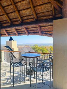 a patio with a table and chairs on a roof at 213 Zebula Golf Estate & Spa - 4 Bedroom Home in Mabula