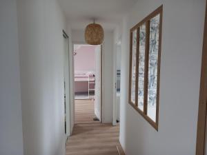 einen Flur mit weißen Wänden und einem Spiegel in der Unterkunft Maison 10 personnes dans le Morbihan in Saint-Avé