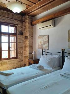 a bedroom with two beds and a window at Vouno Village in Vounós