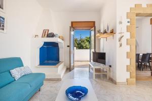 a living room with a blue couch and a fireplace at Villetta Mamapace by BarbarHouse in Punta Prosciutto