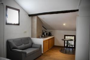 a living room with a couch and a kitchen at Buhardilla barranquilla in Poyales del Hoyo