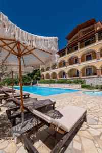 una piscina con sedie e un ombrellone accanto a un edificio di Apart Hotel Alex a Himare