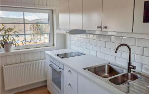 a white kitchen with a sink and a window at Gorgeous Apartment In Bengtsfors in Bengtsfors