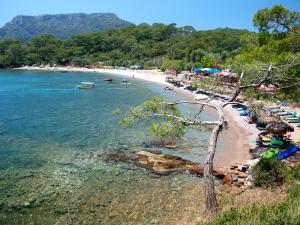 a beach with a bunch of umbrellas and people on it at CC's Butik Hotel in Oludeniz