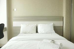 JatirokeComfy Studio Apartment near UNPAD Taman Melati Jatinangor By Travelio的一张铺着白色床单和枕头的大床 更多10张照片