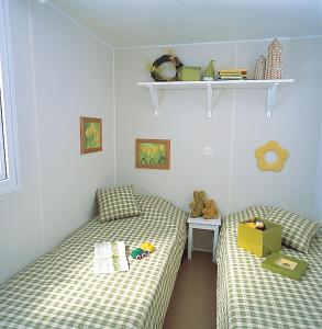 a bedroom with two beds and a shelf at camping les pêcheurs in Pont-de-Poitte +46 photos