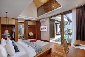 Un dormitorio con una gran cama blanca en una habitación. en Sanora Villa Sanur by Ini Vie Hospitality, en Sanur 34 fotos más