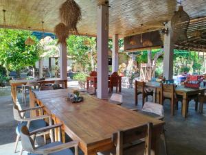 a restaurant with a large wooden table and chairs at Amed Harmony Bungalows And Villas in Amed