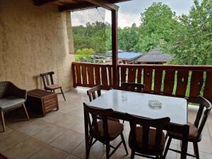 a patio with a table and chairs on a balcony at Morvai Panzió in Mogyoród +17 photos
