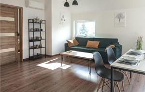 a living room with a green couch and a table at Stunning Apartment In Wilcze With Sauna in Wilcze