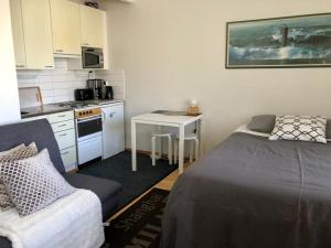 a small kitchen with a bed and a table in a room at Sweet Studio City Center T&ouml;&ouml;l&ouml;nkatu in Helsinki