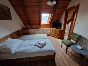a bedroom with a bed and a table and a television at Morvai Panzió in Mogyoród