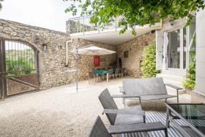 patio con sedie, ombrellone e tavolo di Maison De Vacances Avec Piscine a Gras