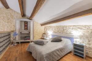 una camera da letto con un letto e un muro di pietra di Maison De Vacances Avec Piscine a Gras Altre 19 foto