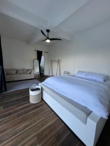 a bedroom with a white bed and a ceiling fan at Enla Montana villa private pool and hot spring in Kubupenlokan