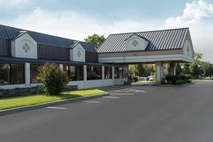 a building with a parking lot in front of it at Lamplighter Inn & Suites Pittsburg in Pittsburg