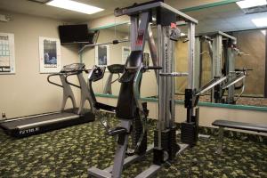 a gym with several tread machines in a room at Lamplighter Inn & Suites Pittsburg in Pittsburg