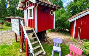 a small red and white house with chairs and a ladder at Lovely Home In Ånimskog With Wifi in Ånimskog