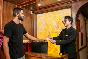 two men shaking hands in front of a counter at The West Hotel & Spa in Hanoi