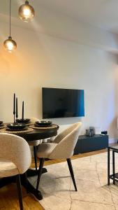 a dining room with a table and chairs and a tv at Formionos Elegance in Kesariani in Athens