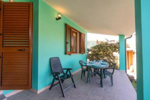 a patio with a table and chairs next to a house at Casa Shanti - 5 Minuti dalla Spiaggia con Piscina Condominiale in Santa Caterina