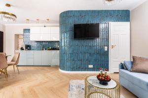 a living room with a couch and a blue wall at Rooftop Wawel view with jacuzzi l luxury apartment in Kraków