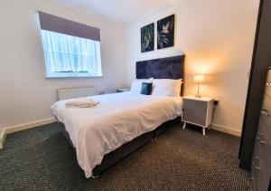 a bedroom with a large bed and a window at Aisiki Stays Apartments at Harwoods Road, Multiple 2-Bedroom, Pet-Friendly Flat, King or Twin or Double Beds, with Free WiFi and Parking Space in Watford