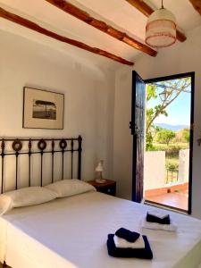 una camera da letto con un letto e una grande finestra di Cortijo de la Fuente con vistas impresionantes y playas a 20 minutos a Bédar