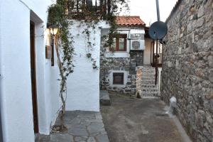 萨莫色雷斯Kactro House的一条小巷,有一座白色的建筑,设有窗户